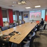 Sala konferencyjna z widokiem na ekran z transmisją konferencji online